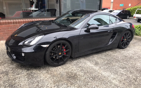 A black Porsche parked outside Blackburn Car Care service workshop