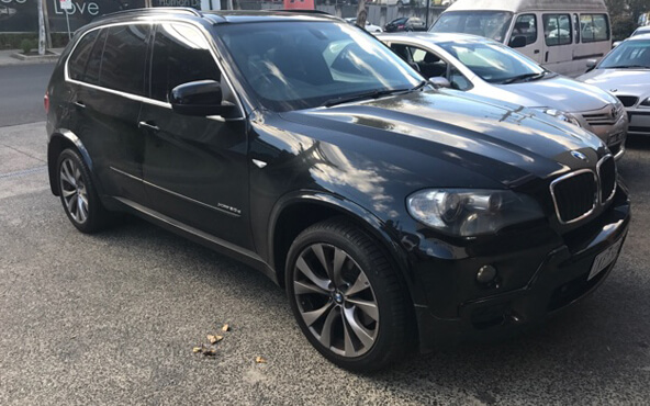 A black BMW SUV parked outside Blackburn Car Care service workshop